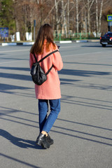 the girl with a mobile phone in her hand is on the street