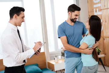 Obraz premium Młoda para przytulanie i uśmiechanie się do siebie w jasnym biurze.