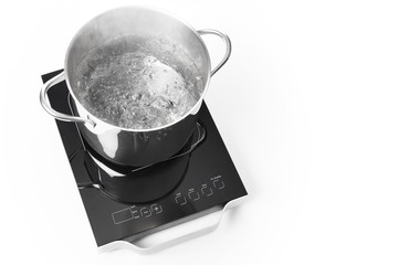 Portable induction cooktop and frying pan on white background