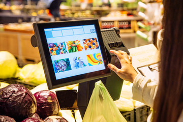woman put onions on weight on store. grocery shopping