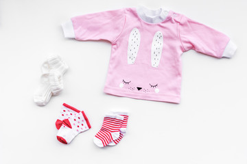 Newborn baby's background. Clothes for small girl with booties on white top view