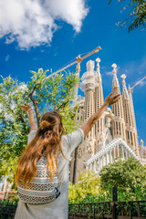 Girl tourist near Sagrada Familia. Architecture Antonio Gaudi. A woman with long hair and a...