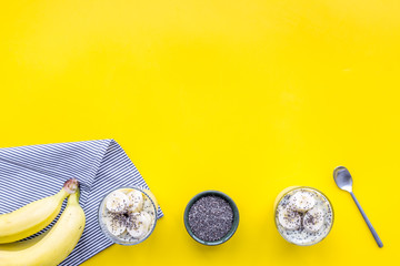 Idea for healthy breakfast. Banana pudding with chia seeds on yellow table with blue tablecloth top view copy space