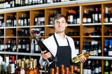 Man seller wearing uniform having bottle of wine