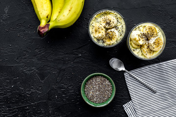 Banana pudding with chia seeds as low-calorie tasty appetizer. Black background with blue tablecloth top view space for text closeup