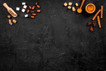 Ingredients for sweet bakery. Cinnamon, cocoa, sugar, on black table top view copy space