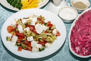 Colorful salad of fresh organic vegetables on white plate closeup. Cold appetizer for guests on banquet table. Healthy food concept