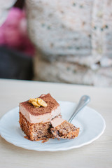 Woman eating small cake in a restaurant.