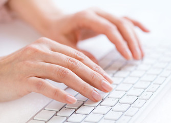 Woman's hands typing on keyboard