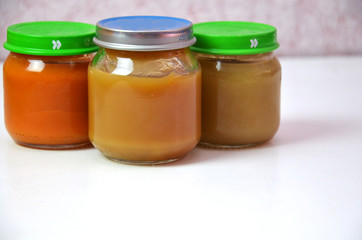 Three jars of baby food on white.