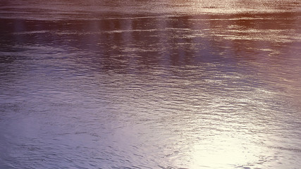 water surface with ripples. Reflection of the sun. natural background.