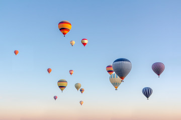Naklejka premium Bright multi-colored hot air balloons flying in sunsrise sky Cappadocia