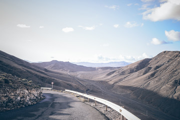 narrow serpentine mountain road in arid landscape on Fuerteventura island, Spain