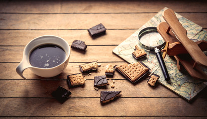 White cup with coffee and wooden plane on a table. High angle view