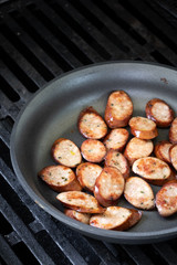 Top down view on sliced sausage in a nonstick pan with space on top