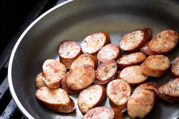  Close up on sliced sausage in a nonstick pan with space for text on top