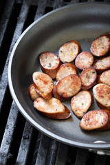  Close up on sliced sausage in a frying pan with space for text on left