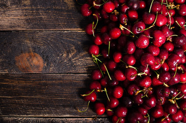 Cherry background. Fresh juicy cherries on wooden background, top view. Free space for your text
