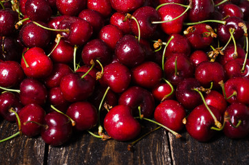 Cherry background. Fresh juicy cherries on wooden background, top view. Free space for your text