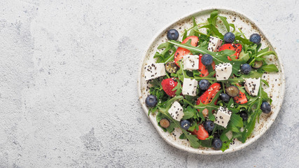 Salad with arugula, feta, strawberry, blueberry