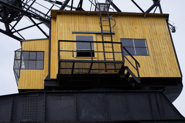 gelbes Holzhaus Kranhaus schwarze Leiter offenes Fenster