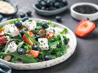 Salad with arugula, feta, strawberry, blueberry