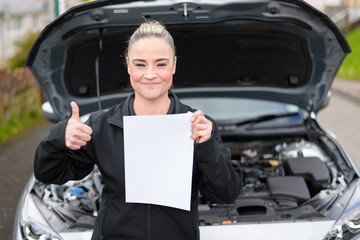 Fototapeta na wymiar A woman car mechanic with blank sheet for service report or copy space