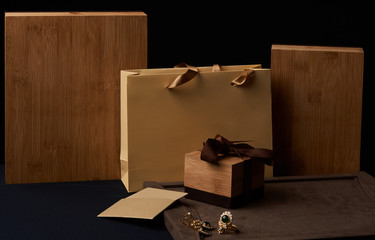 Women's diamond jewelry earrings and a ring with a green emerald stone and gift boxes with shopping bags. Empty cards with copy space for your text