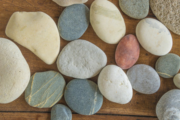 Various of pebbles on wooden background top view