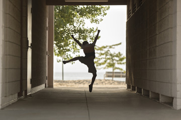 Full length of excited boy jumping at covered walkway