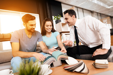 Two men and a woman are discussing the purchase of new furniture.