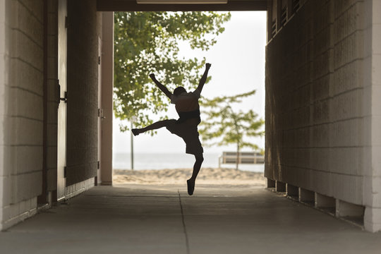 Full length of excited boy jumping at covered walkway