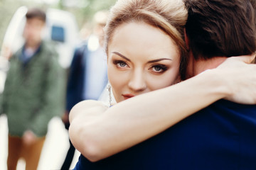 Fototapeta premium Happy newlywed bride hugging groom after wedding ceremony outdoors face close-up, newlywed couple portrait