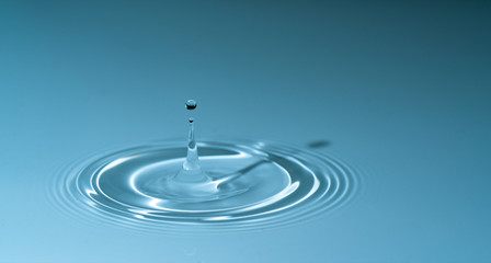 Fototapeta na wymiar splash drop of water on blue background