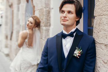 Gorgeous, sexy bride looking at happy handsome groom, newlywed couple portrait, beautiful bride face looking at stylish groom in suit, emotional wedding moment