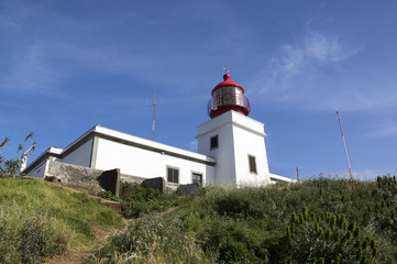 Fototapeta na wymiar White romantic lighthouse on the cliff, west Madeira island, village Ponta do Pargo, Portugal, Atlantic ocean