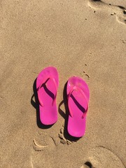 Fototapeta na wymiar Pink Flip Flops in the Sand at the Beach outside of Lisbon 