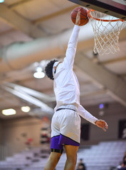 Basketball player making a slam dunk during a game