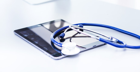 Medical equipment: blue stethoscope and tablet on white background. Medical equipment