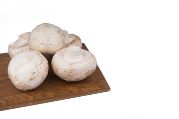 White mushrooms on a wooden cutting Board. Isolate on white background