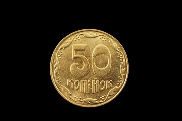 A macro image of a Ukrainian fifty kopiyka coin isolated on a black background