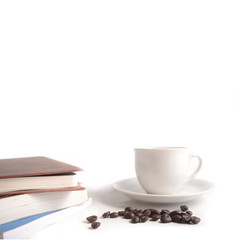 Cup of coffee and coffee beans with stack of books on white background.