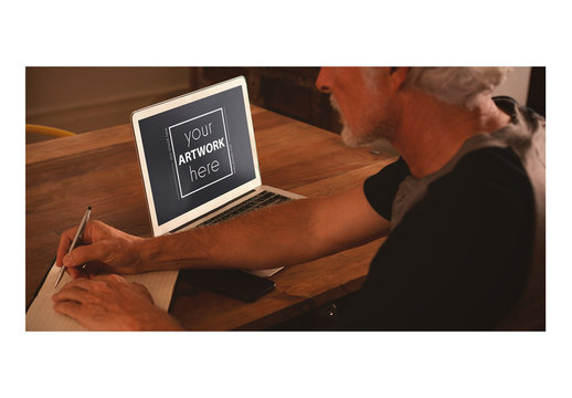 Laptop User Writing in Notebook at Table Mockup