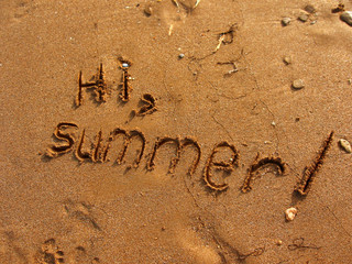 Fototapeta premium Hi, Summer written on the sand. Textured sandy template for vacation concepts. Natural sea beach background