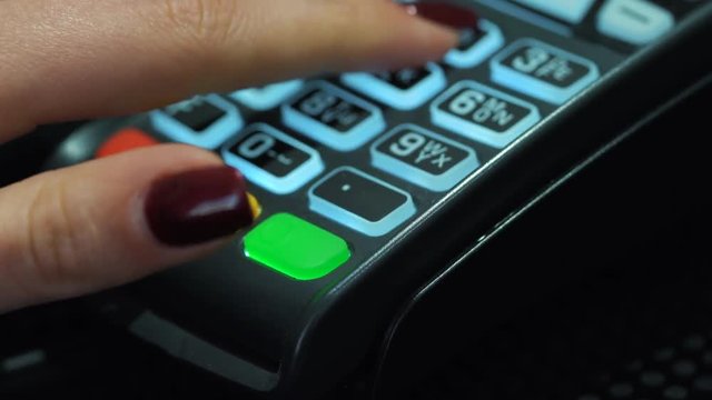 Shop assistant inserting a credit card into a pos and inserting pin-code of the card