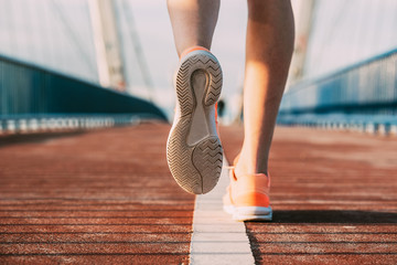 crop woman running on the bridge