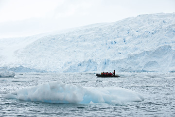 Group of tourists sightseeing on a boat surrounded by icebergs.