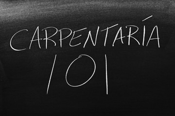 The words Carpintería 101 on a blackboard in chalk.  Translation: Carpentry 101