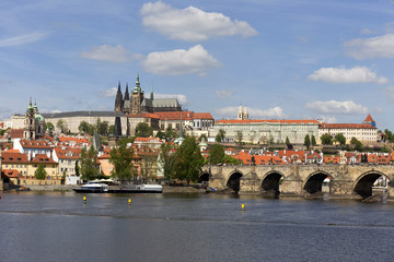Obraz premium Spring green Prague Lesser Town with gothic Castle and Charles Bridge above River Vltava in the sunny Day, Czech Republic