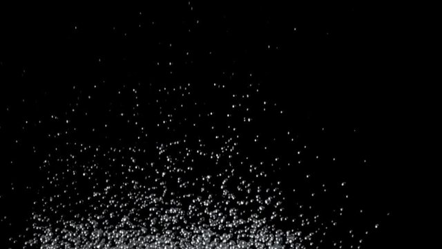 Excitement of the water throws hundreds of drops up. Black background. Slow motion